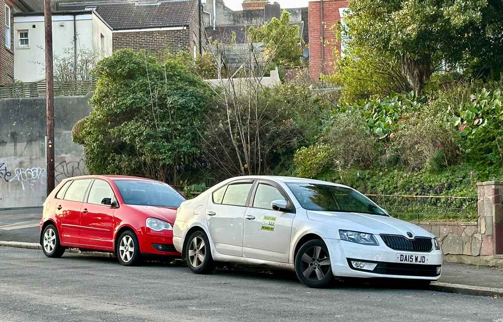 Photograph of DA15 WJD - a White Skoda Octavia taxi parked in Hollingdean by a non-resident. The fourth of ten photographs supplied by the residents of Hollingdean.