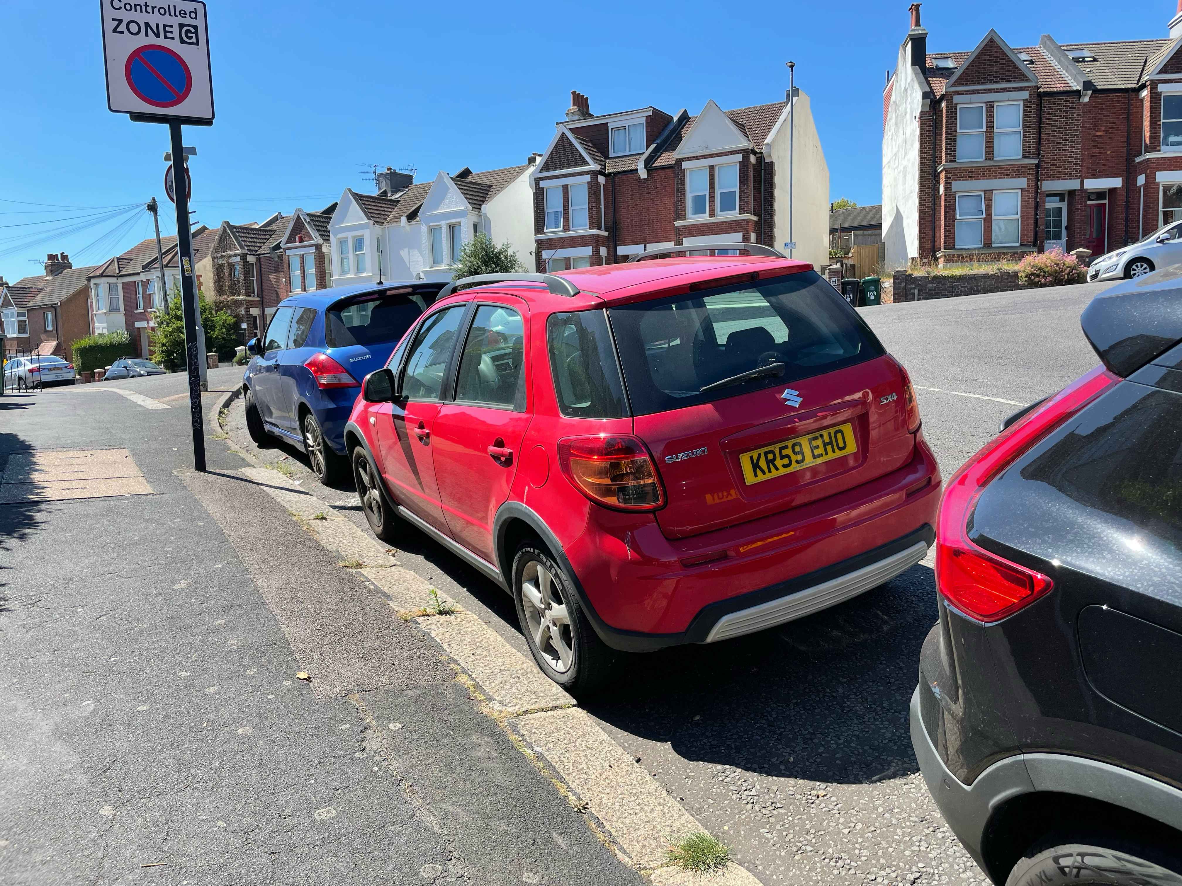 Photograph of KR59 EHO - a Red Suzuki SX4 parked in Hollingdean by a non-resident who uses the local area as part of their Brighton commute. The third of four photographs supplied by the residents of Hollingdean.