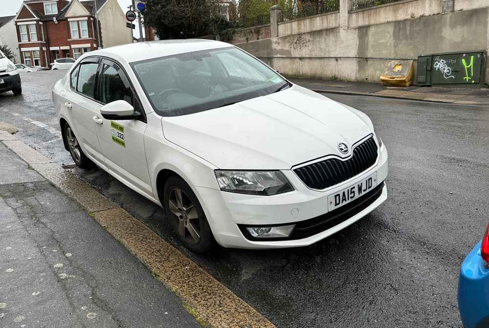 Photograph of DA15 WJD - a White Skoda Octavia taxi parked in Hollingdean by a non-resident. The first of ten photographs supplied by the residents of Hollingdean.