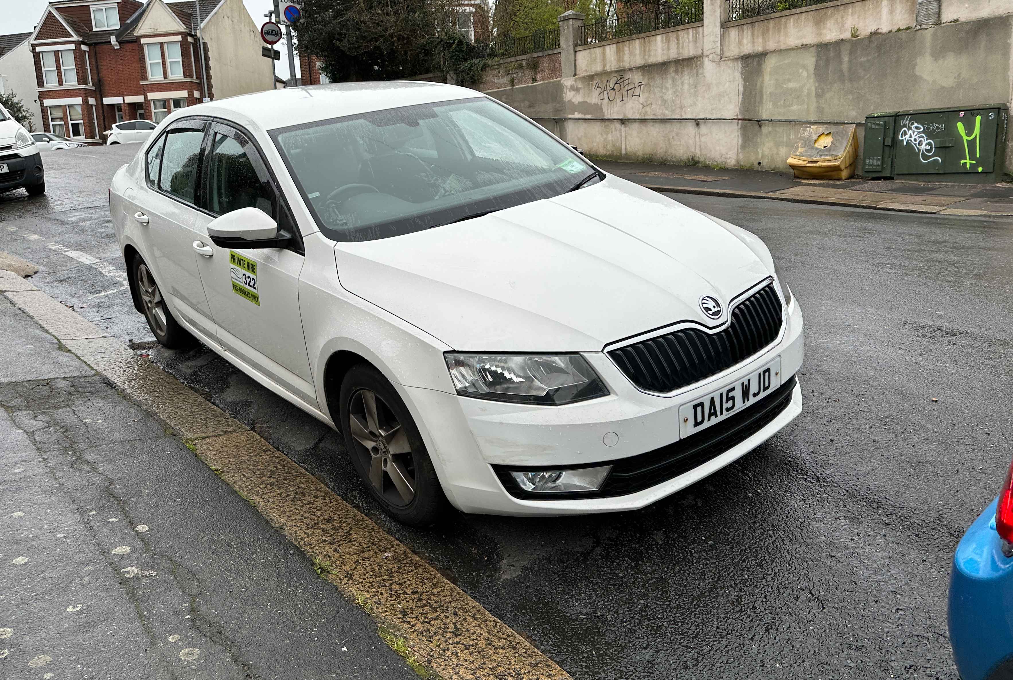 Photograph of DA15 WJD - a White Skoda Octavia taxi parked in Hollingdean by a non-resident. The first of five photographs supplied by the residents of Hollingdean.