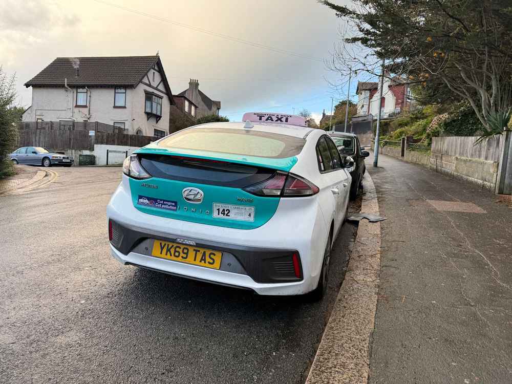 Photograph of YK69 TAS - a White Hyundai Ioniq taxi parked in Hollingdean by a non-resident. The twelfth of fifteen photographs supplied by the residents of Hollingdean.
