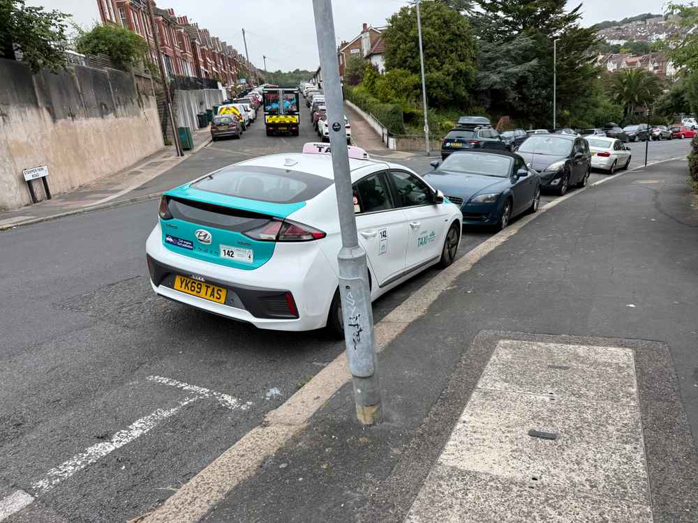 Photograph of YK69 TAS - a White Hyundai Ioniq taxi parked in Hollingdean by a non-resident. The tenth of eleven photographs supplied by the residents of Hollingdean.