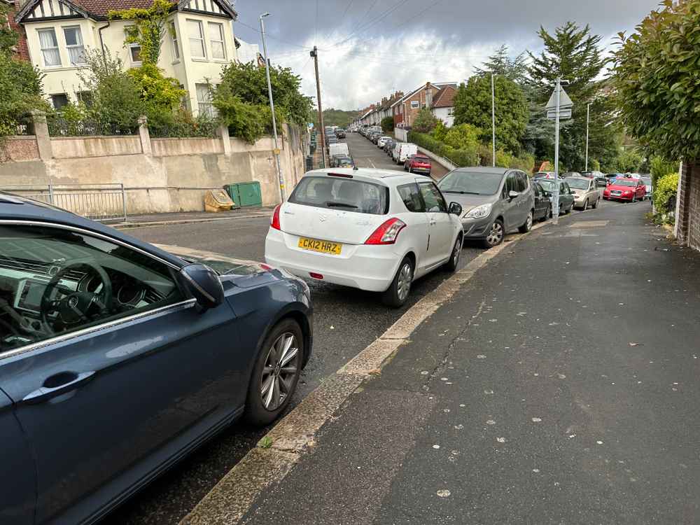 Photograph of CK12 HRZ - a White Suzuki Swift parked in Hollingdean by a non-resident. The fourth of five photographs supplied by the residents of Hollingdean.