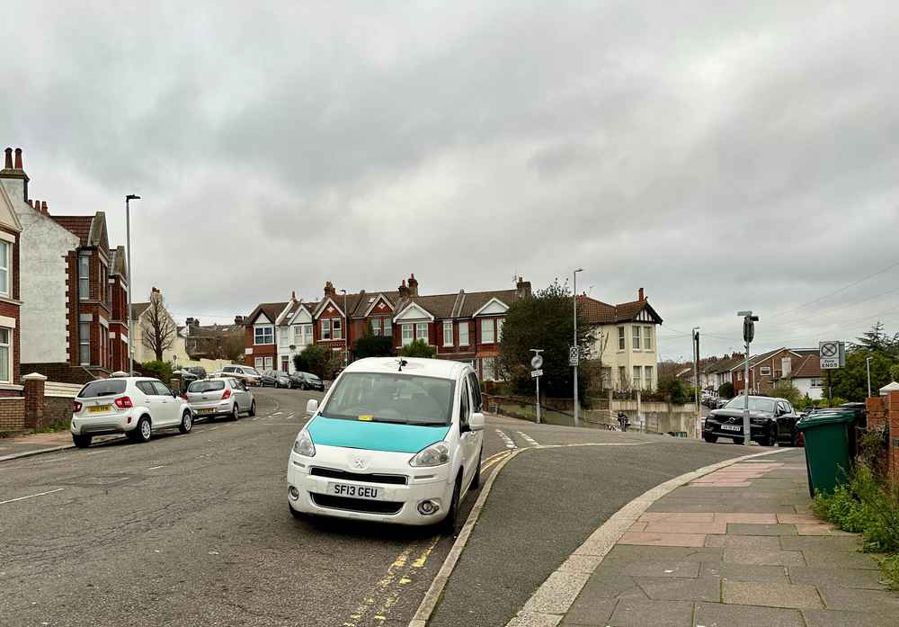 Photograph of SF13 GEU - a White Peugeot Premier taxi parked in Hollingdean by a non-resident, and potentially abandoned. The first of four photographs supplied by the residents of Hollingdean.