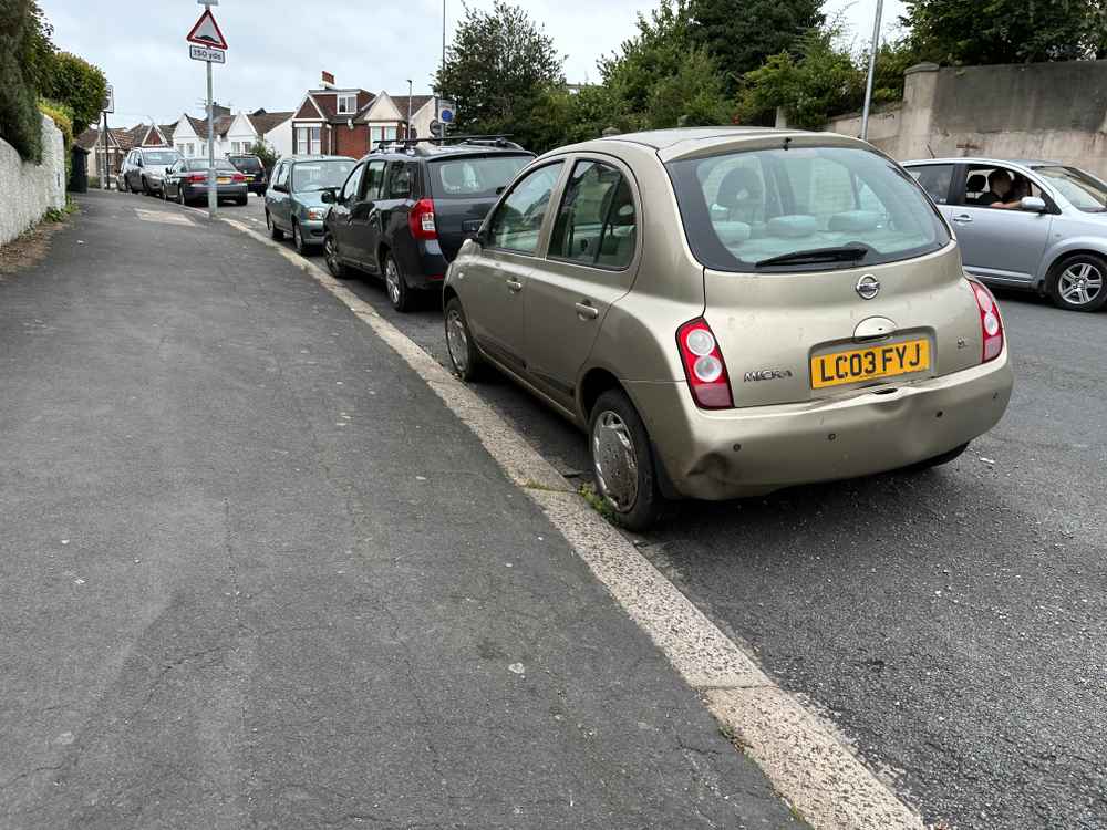 Photograph of LC03 FYJ - a Gold Nissan Micra parked in Hollingdean by a non-resident, and potentially abandoned. The twentieth of twenty-seven photographs supplied by the residents of Hollingdean.