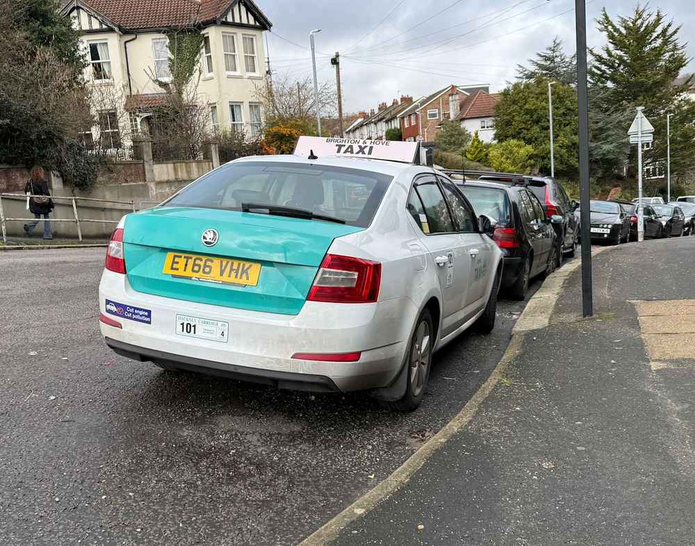 Photograph of ET66 VHK - a White Skoda Octavia taxi parked in Hollingdean. The second of four photographs supplied by the residents of Hollingdean.