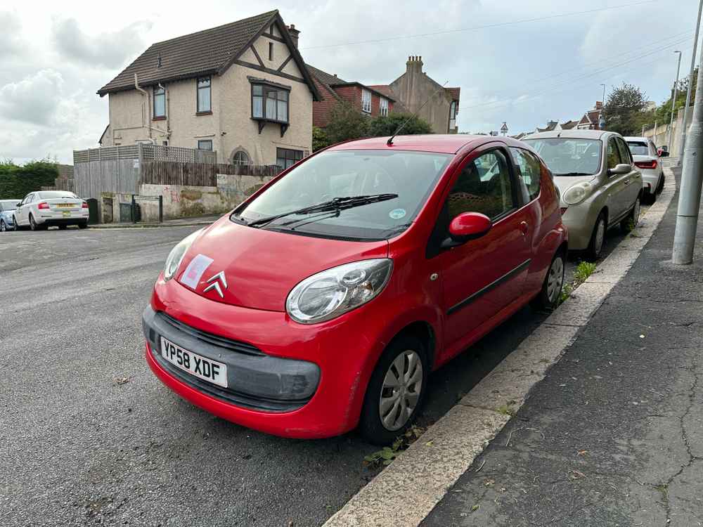 Photograph of YP58 XDF - a Red Citroen C1 parked in Hollingdean by a non-resident, and potentially abandoned. The first of seven photographs supplied by the residents of Hollingdean.