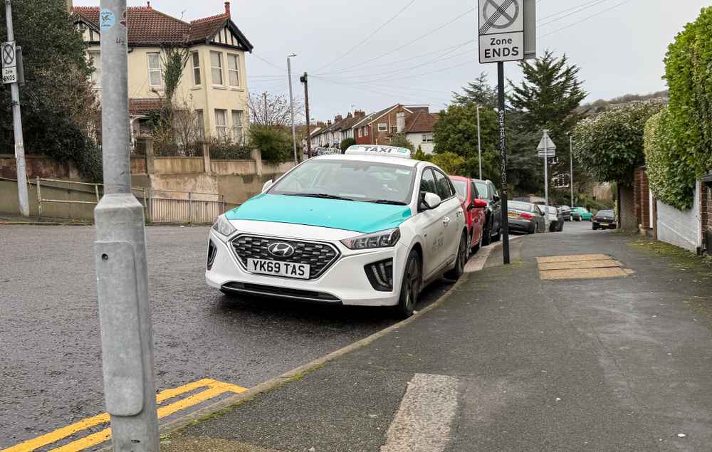 Photograph of YK69 TAS - a White Hyundai Ioniq taxi parked in Hollingdean by a non-resident. The fifth of six photographs supplied by the residents of Hollingdean.