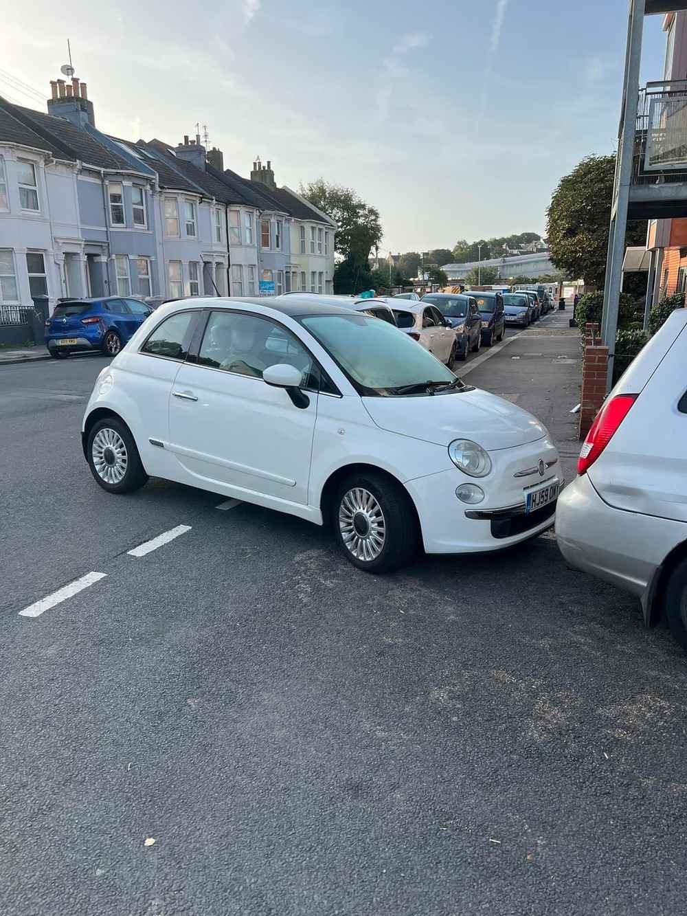 Photograph of HJ59 OMY - a White Fiat 500 parked in Hollingdean by a non-resident who uses the local area as part of their Brighton commute. The first of three photographs supplied by the residents of Hollingdean.