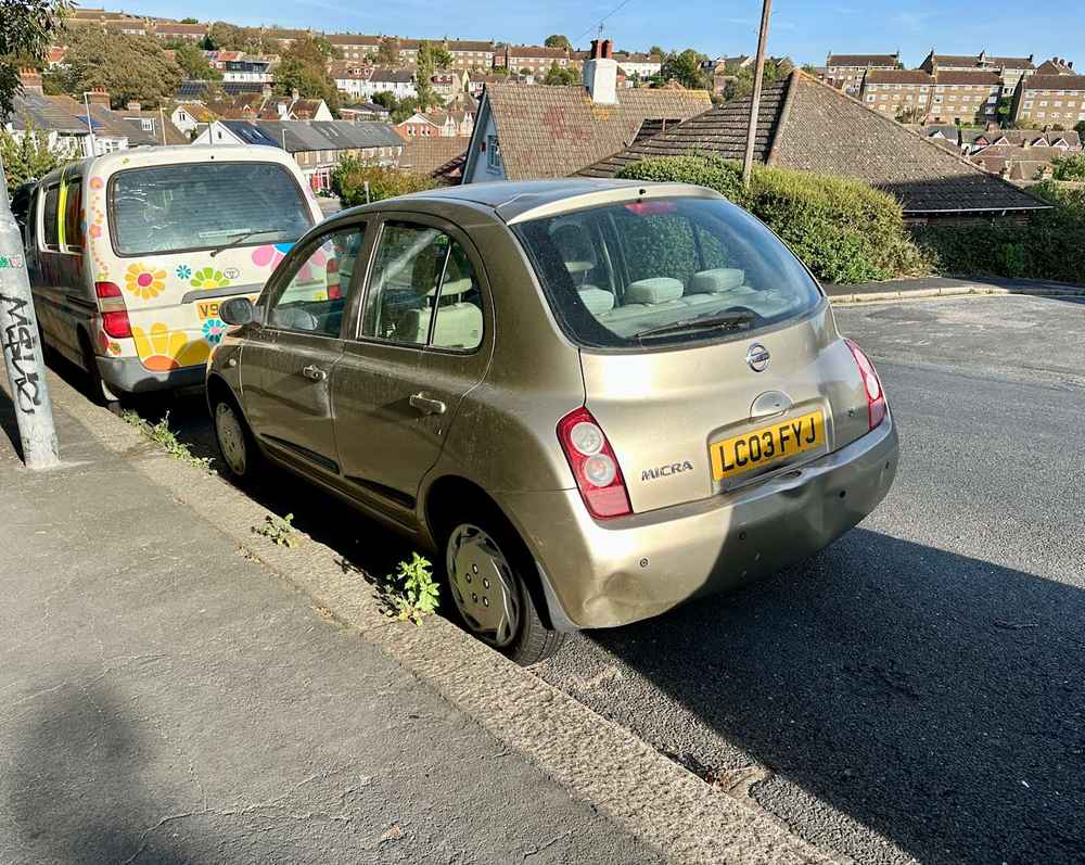 Photograph of LC03 FYJ - a Gold Nissan Micra parked in Hollingdean by a non-resident, and potentially abandoned. The fifth of twenty-eight photographs supplied by the residents of Hollingdean.