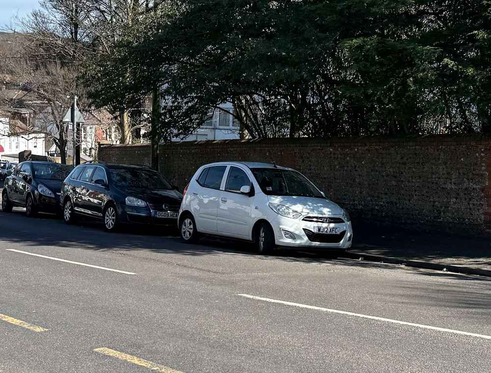 Photograph of WJ12 XFC - a White Hyundai i10 parked in Hollingdean by a non-resident, and potentially abandoned. The second of four photographs supplied by the residents of Hollingdean.