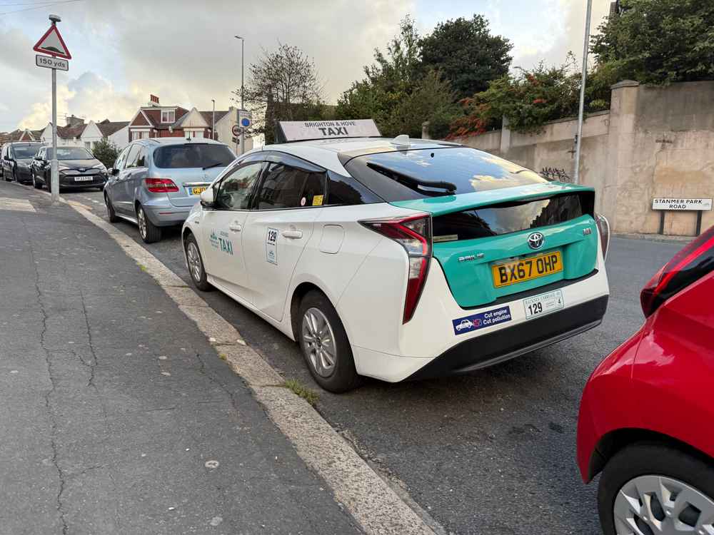 Photograph of BX67 OHP - a White Toyota Prius taxi parked in Hollingdean by a non-resident. The fourth of four photographs supplied by the residents of Hollingdean.