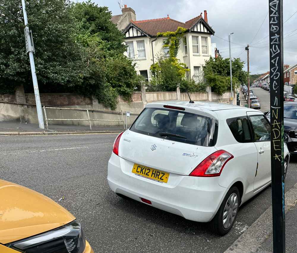 Photograph of CK12 HRZ - a White Suzuki Swift parked in Hollingdean by a non-resident. The third of five photographs supplied by the residents of Hollingdean.