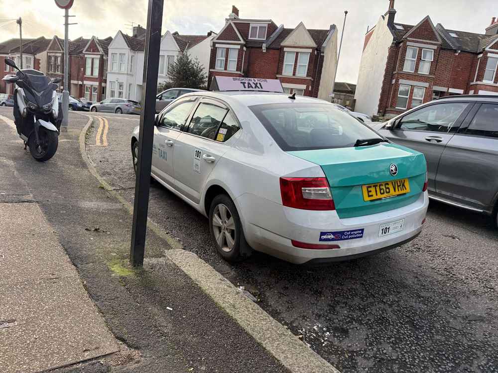 Photograph of ET66 VHK - a White Skoda Octavia taxi parked in Hollingdean. The first of four photographs supplied by the residents of Hollingdean.