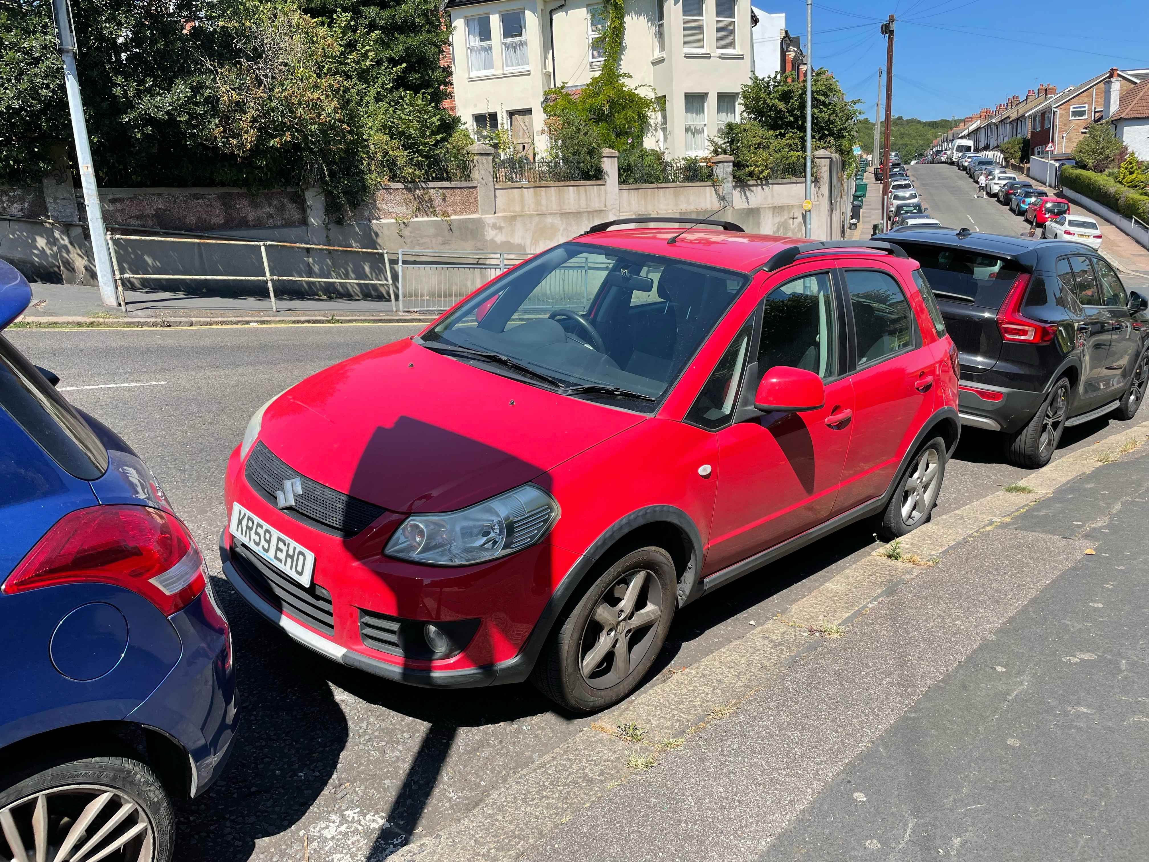 Photograph of KR59 EHO - a Red Suzuki SX4 parked in Hollingdean by a non-resident who uses the local area as part of their Brighton commute. The second of four photographs supplied by the residents of Hollingdean.