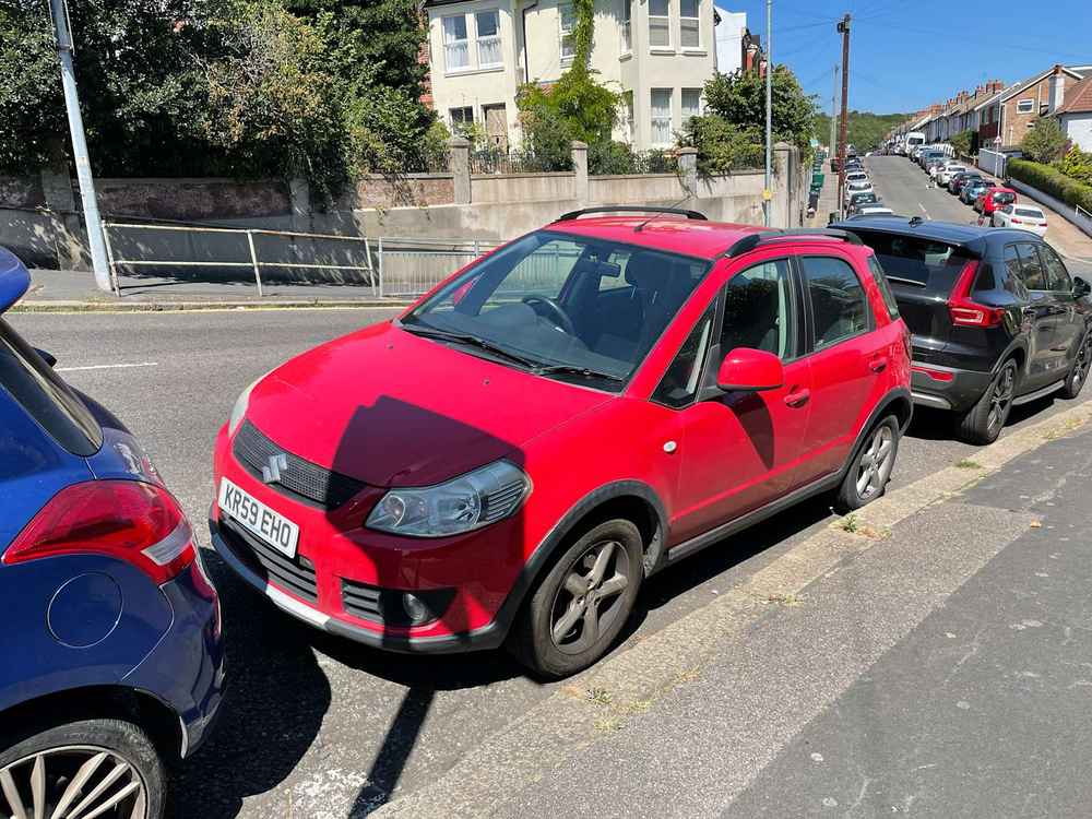 Photograph of KR59 EHO - a Red Suzuki SX4 parked in Hollingdean by a non-resident who uses the local area as part of their Brighton commute. The second of four photographs supplied by the residents of Hollingdean.