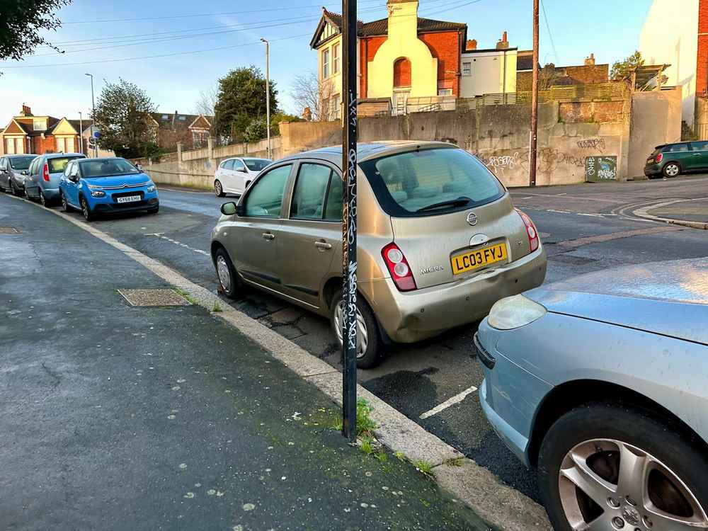 Photograph of LC03 FYJ - a Gold Nissan Micra parked in Hollingdean by a non-resident, and potentially abandoned. The eleventh of twenty-eight photographs supplied by the residents of Hollingdean.
