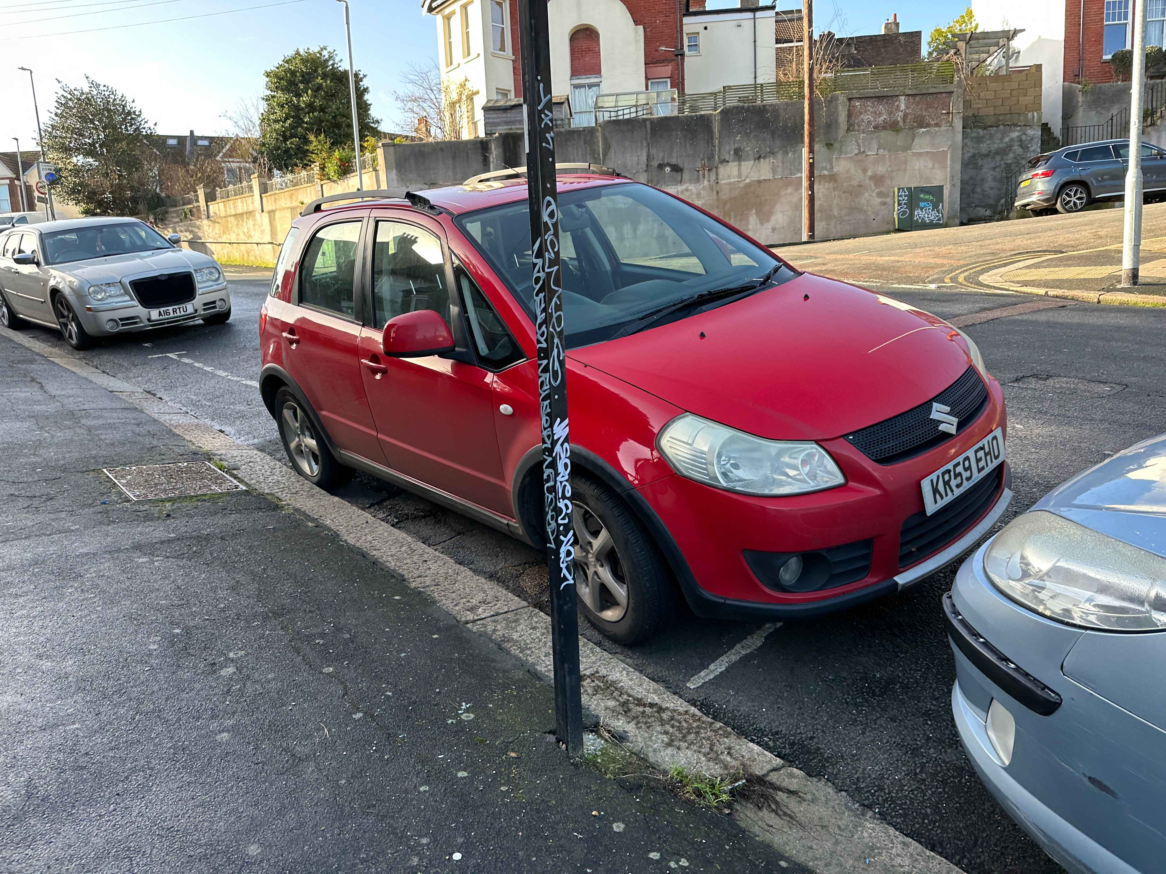 Photograph of KR59 EHO - a Red Suzuki SX4 parked in Hollingdean by a non-resident who uses the local area as part of their Brighton commute. The fourth of four photographs supplied by the residents of Hollingdean.