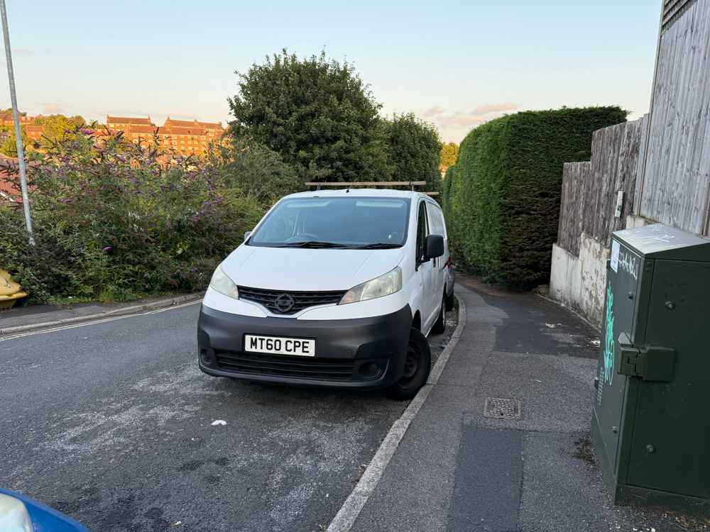 Photograph of MT60 CPE - a White Nissan NV200 parked in Hollingdean by a non-resident, and potentially abandoned. The sixth of seven photographs supplied by the residents of Hollingdean.