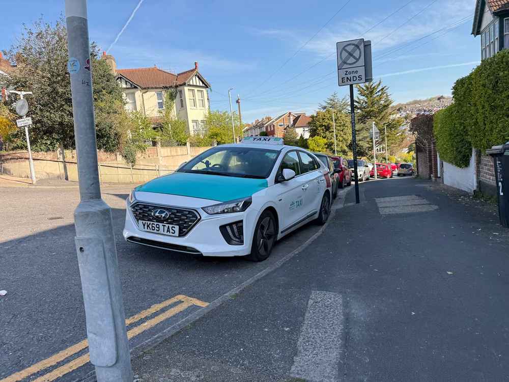 Photograph of YK69 TAS - a White Hyundai Ioniq taxi parked in Hollingdean by a non-resident. The sixth of fifteen photographs supplied by the residents of Hollingdean.