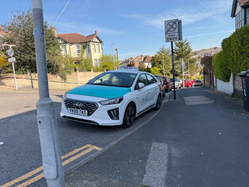 Photograph of YK69 TAS - a White Hyundai Ioniq taxi parked in Hollingdean by a non-resident. The sixth of six photographs supplied by the residents of Hollingdean.