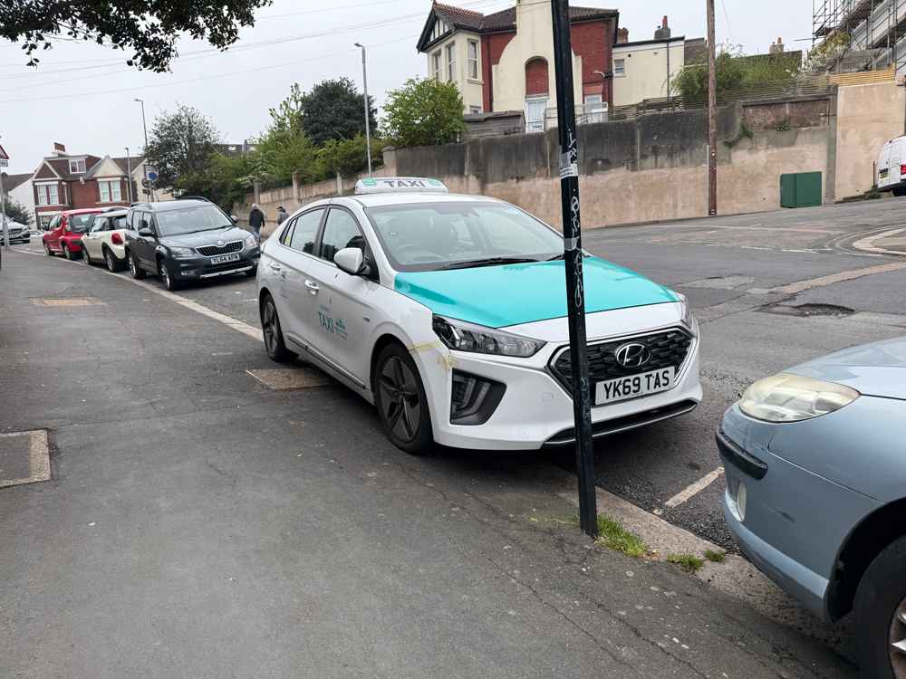 Photograph of YK69 TAS - a White Hyundai Ioniq taxi parked in Hollingdean by a non-resident. The seventh of seven photographs supplied by the residents of Hollingdean.