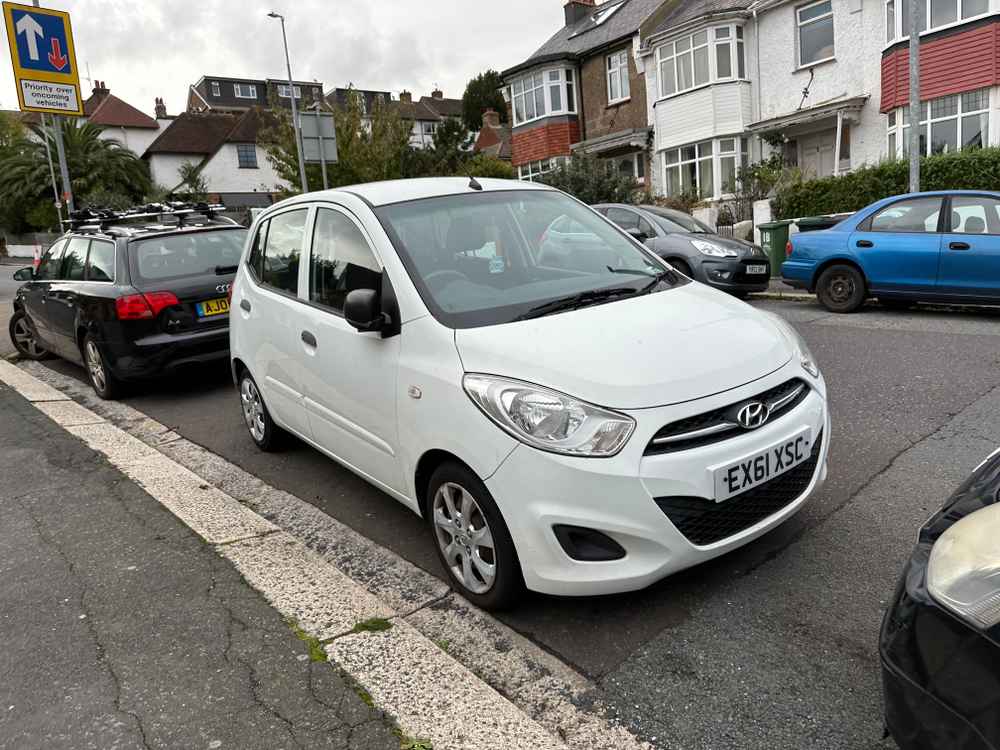 Photograph of EX61 XSC - a White Hyundai i10 parked in Hollingdean by a non-resident who uses the local area as part of their Brighton commute. The first of three photographs supplied by the residents of Hollingdean.