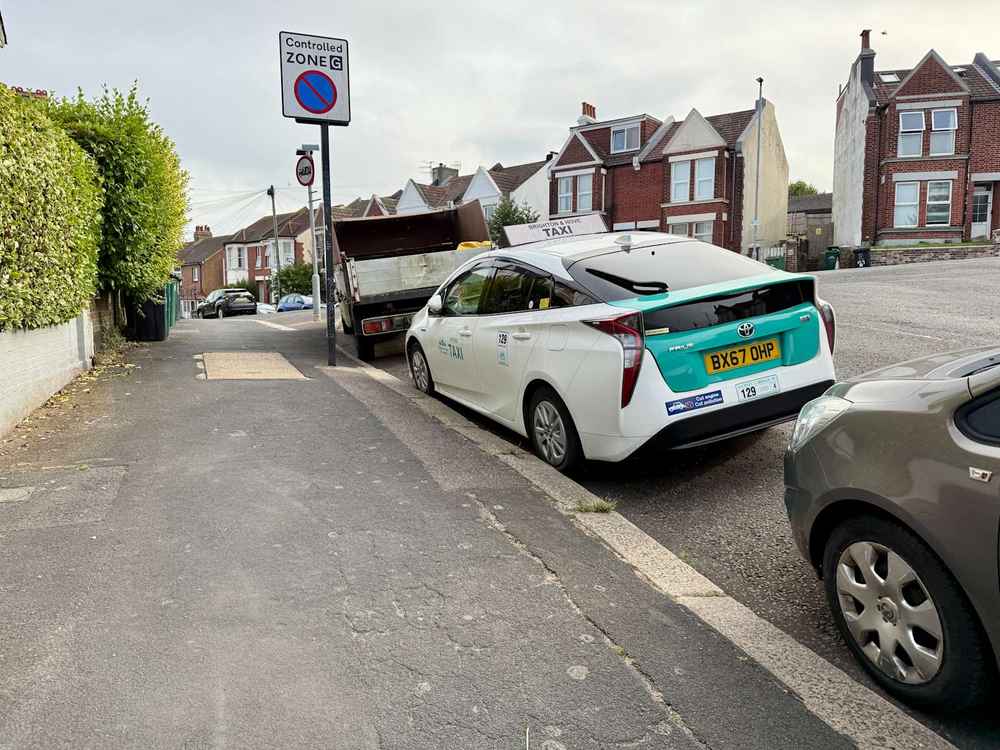 Photograph of BX67 OHP - a White Toyota Prius taxi parked in Hollingdean by a non-resident. The third of five photographs supplied by the residents of Hollingdean.