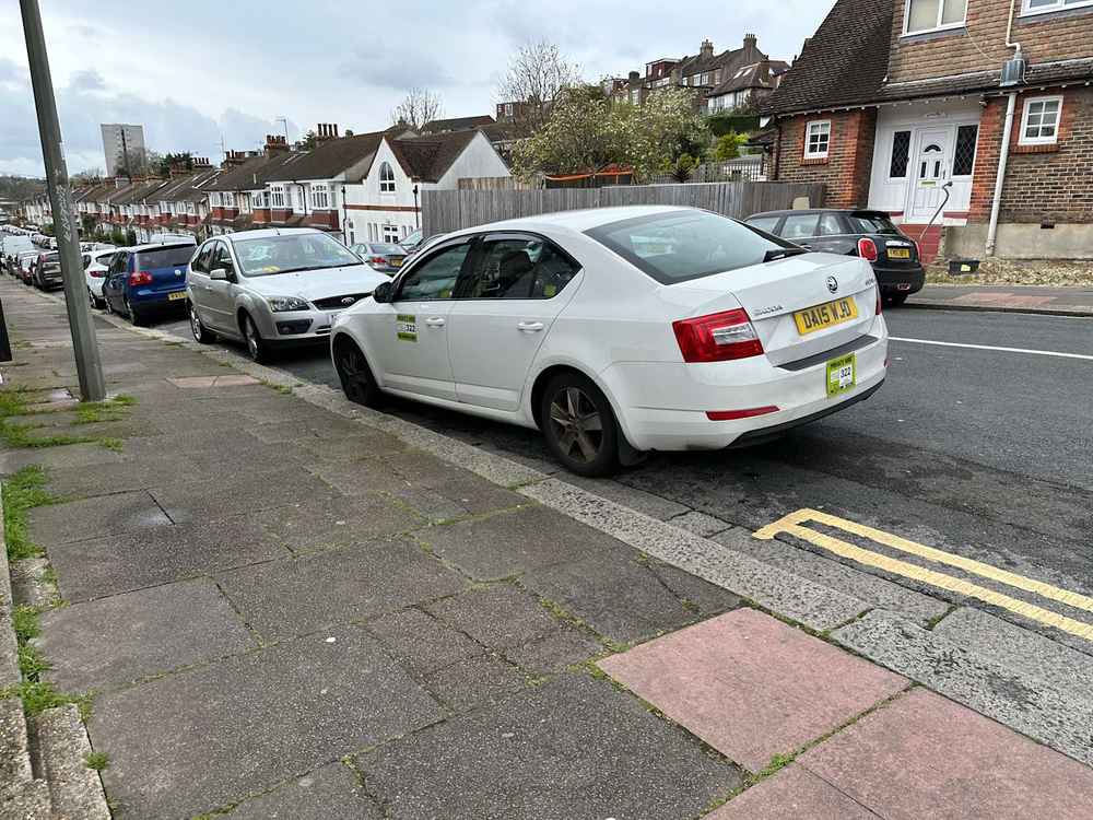 Photograph of DA15 WJD - a White Skoda Octavia taxi parked in Hollingdean by a non-resident. The seventh of nineteen photographs supplied by the residents of Hollingdean.