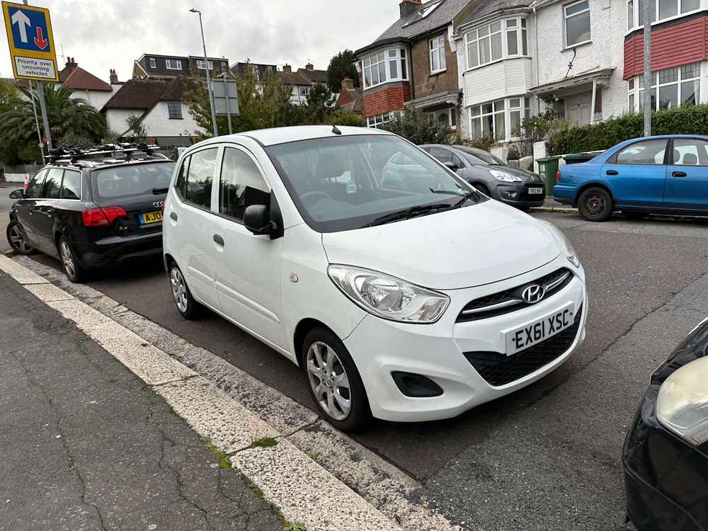 Photograph of EX61 XSC - a White Hyundai i10 parked in Hollingdean by a non-resident who uses the local area as part of their Brighton commute. The first of seven photographs supplied by the residents of Hollingdean.