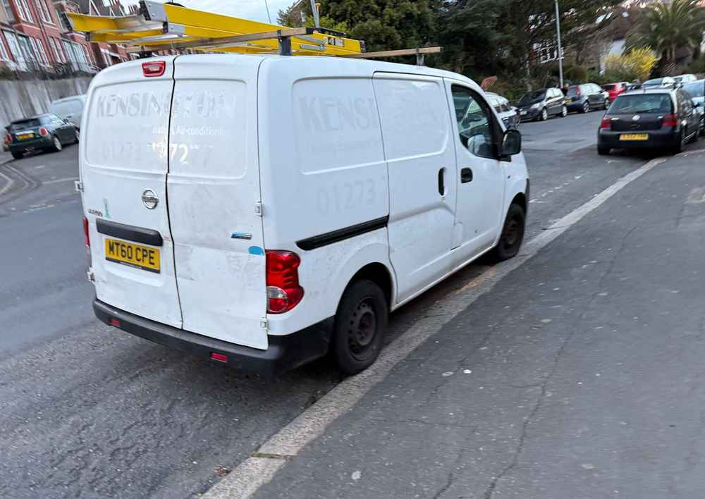 Photograph of MT60 CPE - a White Nissan NV200 parked in Hollingdean by a non-resident, and potentially abandoned. The first of fourteen photographs supplied by the residents of Hollingdean.