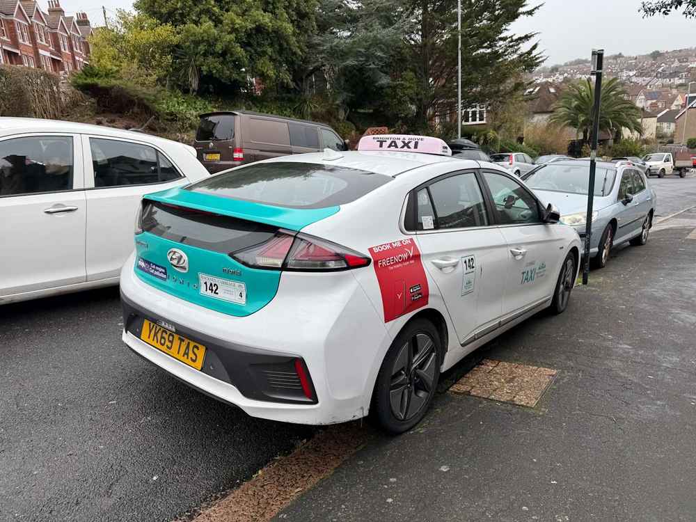 Photograph of YK69 TAS - a White Hyundai Ioniq taxi parked in Hollingdean by a non-resident. The fourth of fifteen photographs supplied by the residents of Hollingdean.
