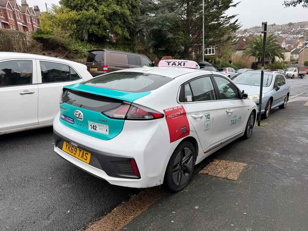 Photograph of YK69 TAS - a White Hyundai Ioniq taxi parked in Hollingdean by a non-resident. The fourth of six photographs supplied by the residents of Hollingdean.