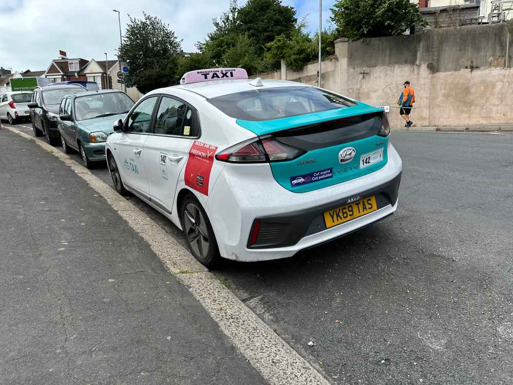 Photograph of YK69 TAS - a White Hyundai Ioniq taxi parked in Hollingdean by a non-resident. The third of six photographs supplied by the residents of Hollingdean.