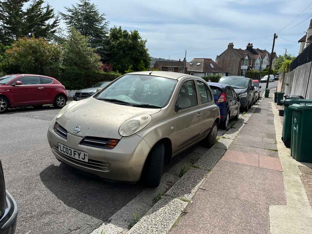 Photograph of LC03 FYJ - a Gold Nissan Micra parked in Hollingdean by a non-resident, and potentially abandoned. The nineteenth of twenty-seven photographs supplied by the residents of Hollingdean.