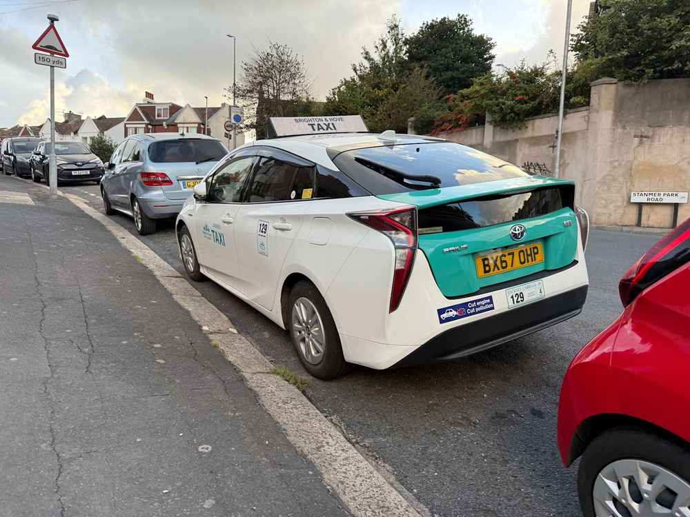 Photograph of BX67 OHP - a White Toyota Prius taxi parked in Hollingdean by a non-resident. The fourth of five photographs supplied by the residents of Hollingdean.