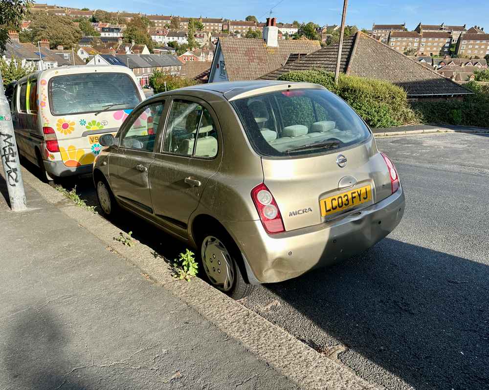 Photograph of LC03 FYJ - a Gold Nissan Micra parked in Hollingdean by a non-resident, and potentially abandoned. The fifth of twenty-three photographs supplied by the residents of Hollingdean.