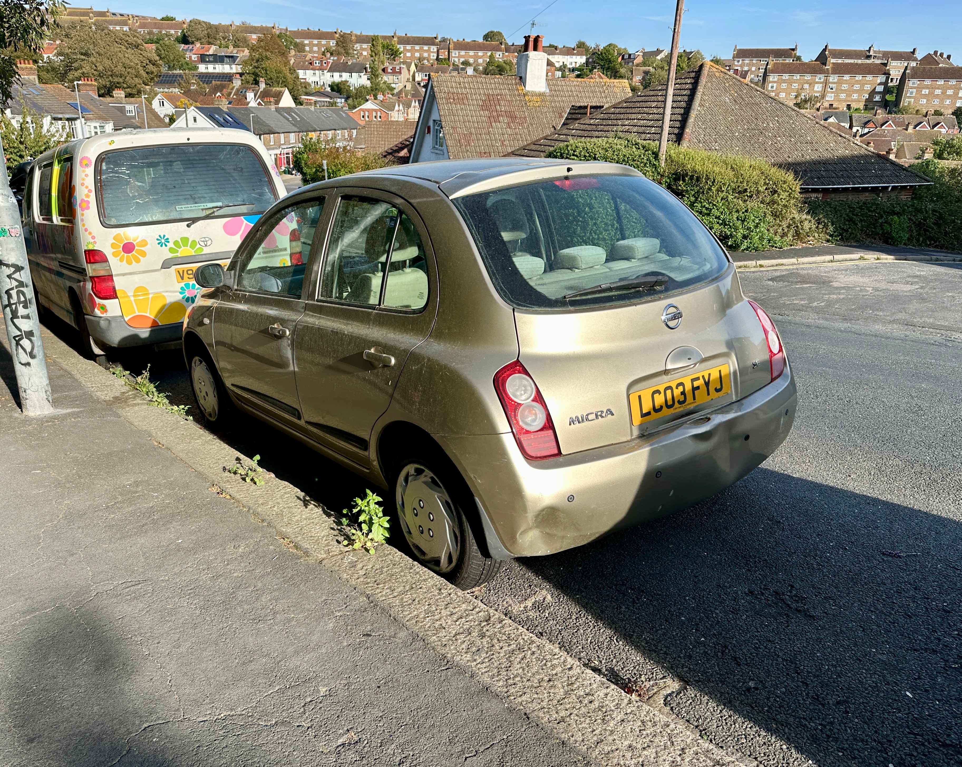 Photograph of LC03 FYJ - a Gold Nissan Micra parked in Hollingdean by a non-resident, and potentially abandoned. The fifth of seventeen photographs supplied by the residents of Hollingdean.