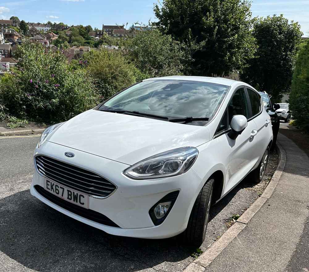 Photograph of EK67 BWC - a White Ford Fiesta parked in Hollingdean by a non-resident. 