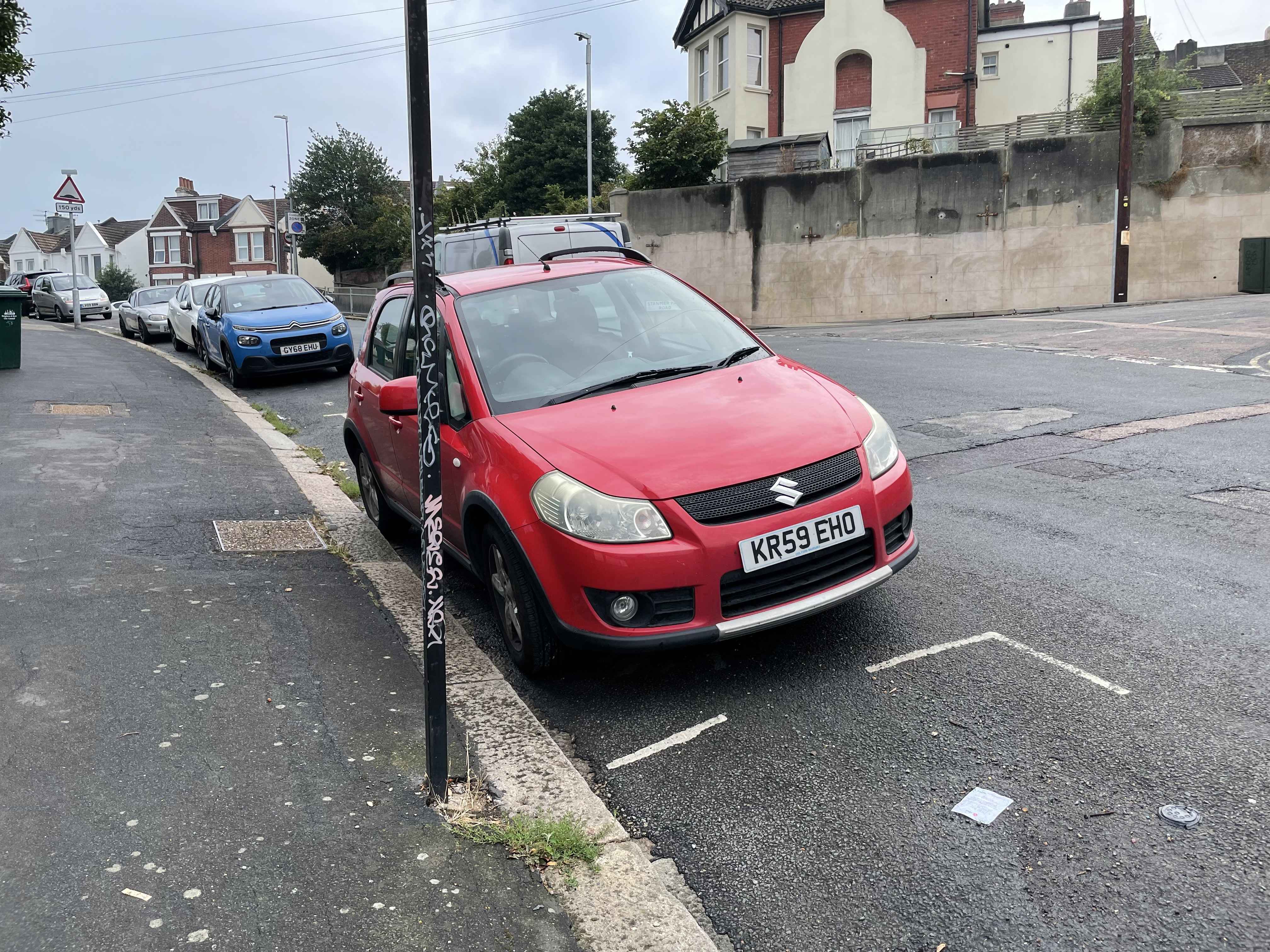 Photograph of KR59 EHO - a Red Suzuki SX4 parked in Hollingdean by a non-resident who uses the local area as part of their Brighton commute. The first of four photographs supplied by the residents of Hollingdean.