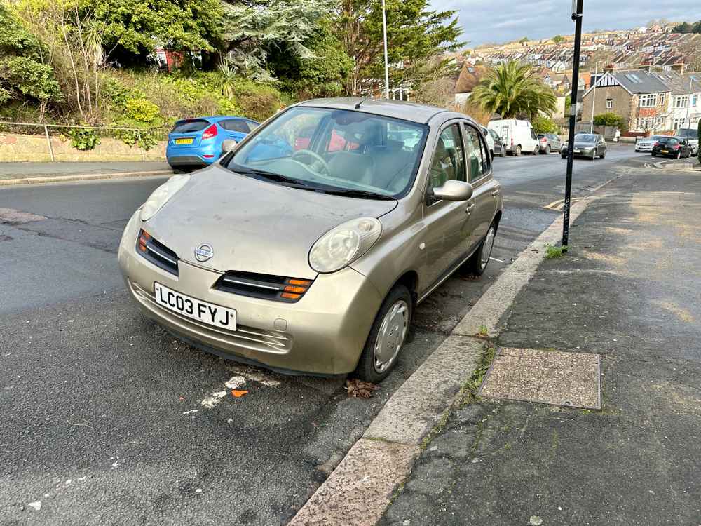 Photograph of LC03 FYJ - a Gold Nissan Micra parked in Hollingdean by a non-resident, and potentially abandoned. The twelfth of twenty-three photographs supplied by the residents of Hollingdean.
