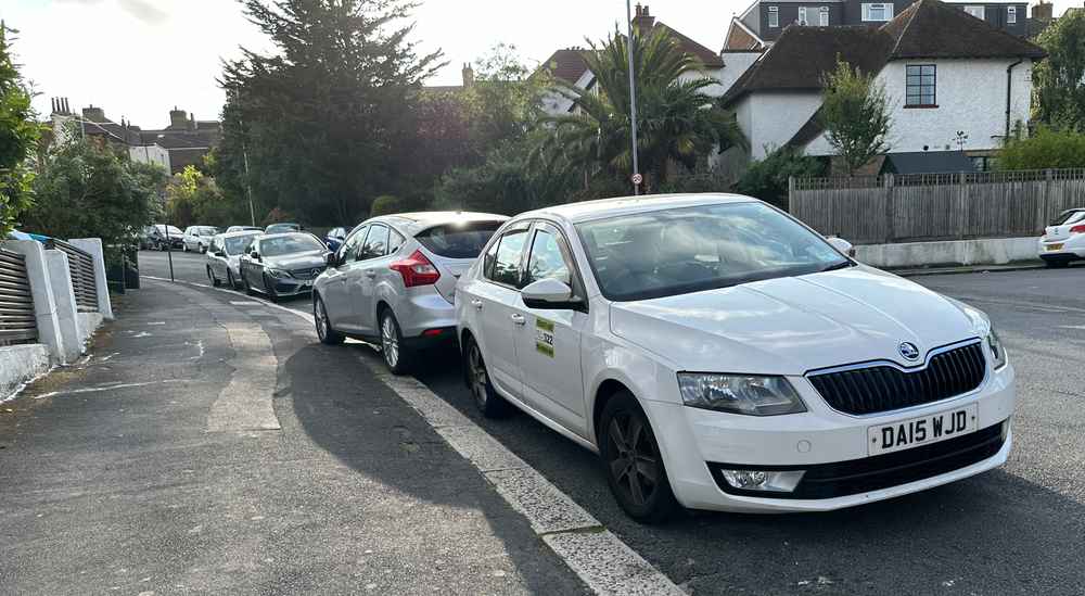 Photograph of DA15 WJD - a White Skoda Octavia taxi parked in Hollingdean by a non-resident. The eleventh of thirteen photographs supplied by the residents of Hollingdean.