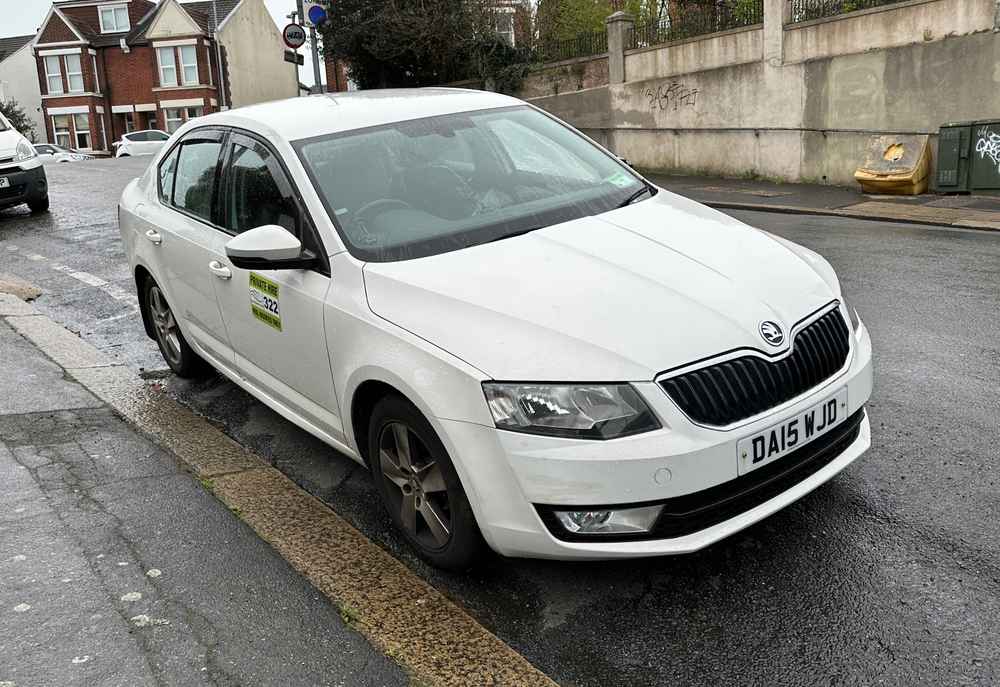 Photograph of DA15 WJD - a White Skoda Octavia taxi parked in Hollingdean by a non-resident. The first of thirteen photographs supplied by the residents of Hollingdean.