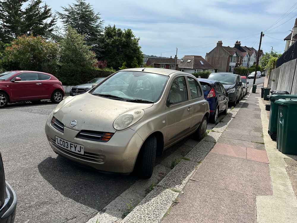 Photograph of LC03 FYJ - a Gold Nissan Micra parked in Hollingdean by a non-resident, and potentially abandoned. The nineteenth of twenty-eight photographs supplied by the residents of Hollingdean.