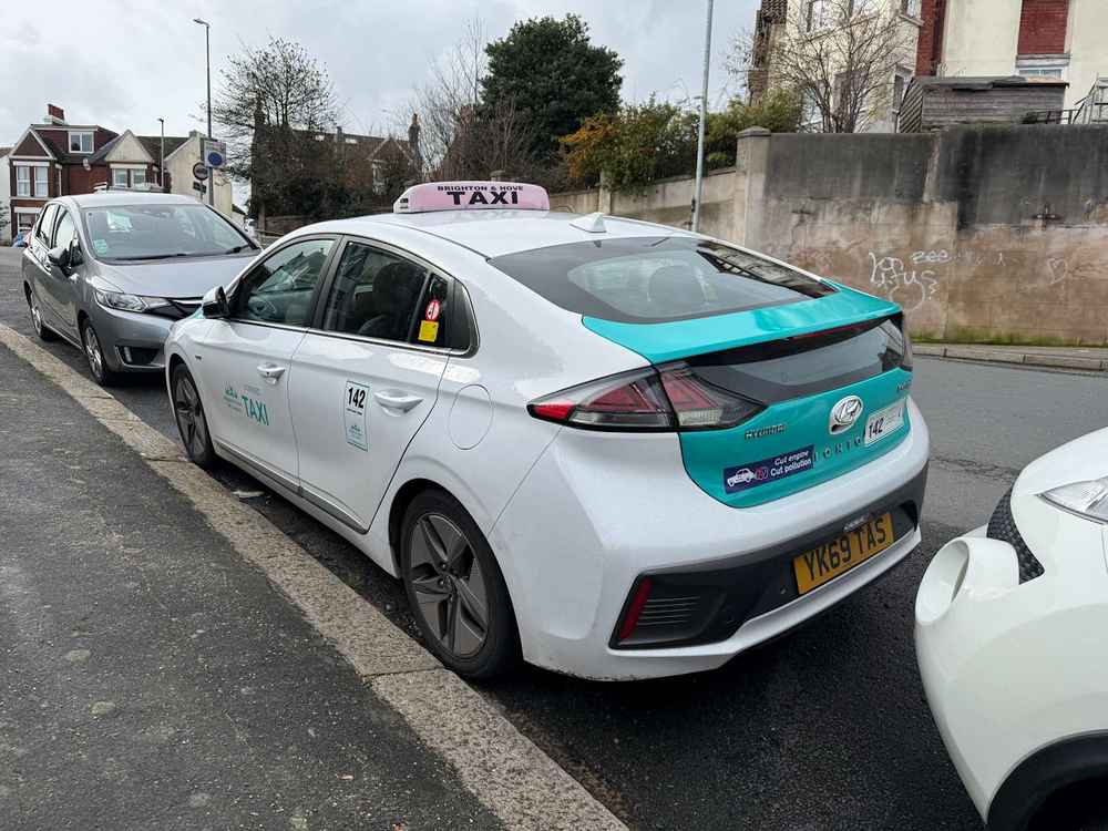 Photograph of YK69 TAS - a White Hyundai Ioniq taxi parked in Hollingdean by a non-resident. The sixteenth of sixteen photographs supplied by the residents of Hollingdean.